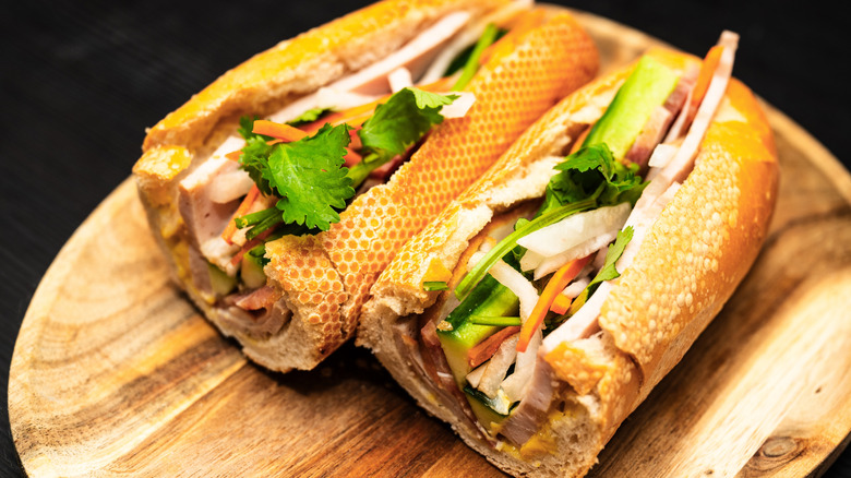 A bánh mì sandwich on a wooden cutting board