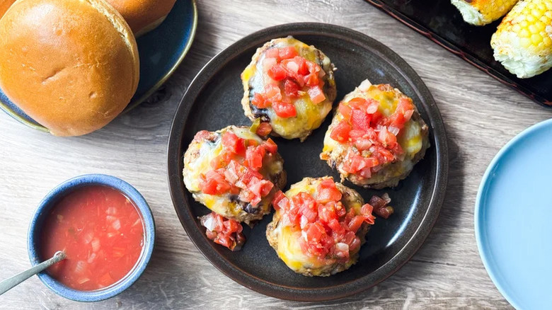 A platter of Juicy 3-Ingredient Tex-Mex Turkey Burgers with bread, corn, and salsa beside it