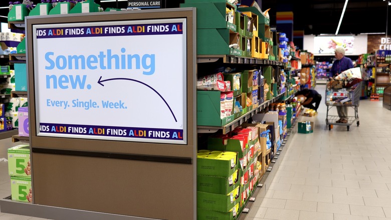Shopper perusing aisle next to an Aldi Finds sign