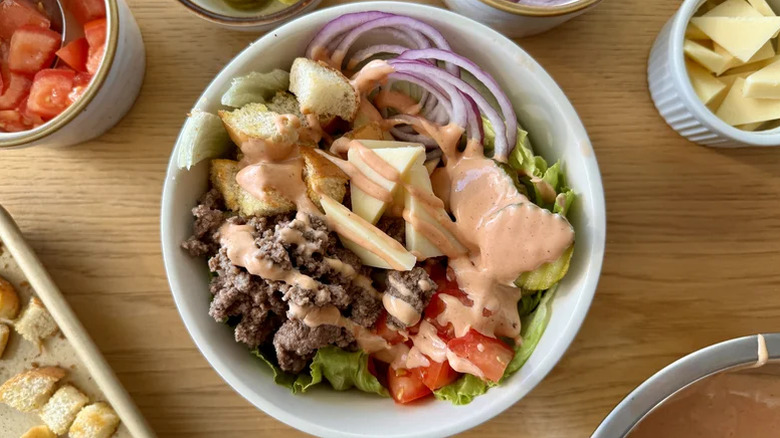 Deluxe cheeseburger bowl with special sauce served in a white dish