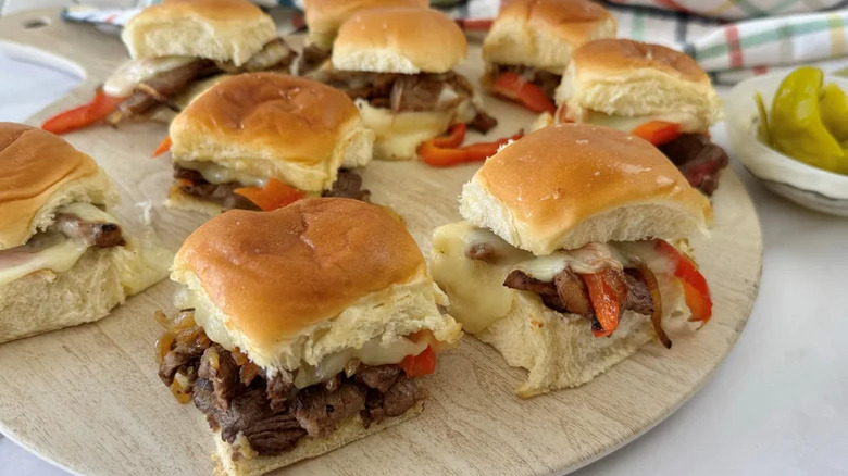 Philly cheesesteak-style sliders served on a wooden board