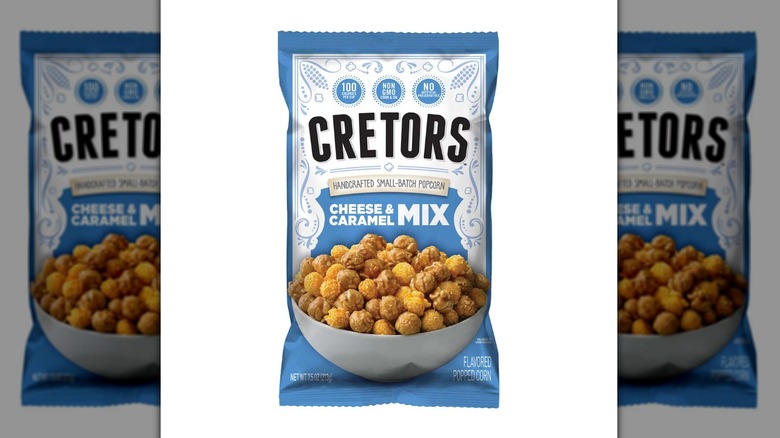 Blue and white 7.5-ounce bag of Cretors cheese and caramel popcorn mix on a white background.