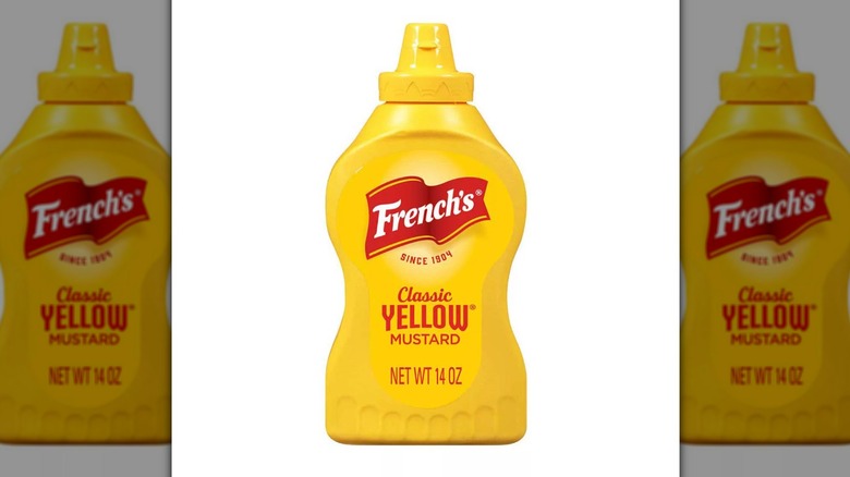 14-ounce container of French's classic yellow mustard on a white background.