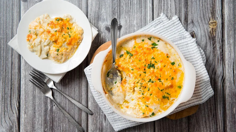 Serving bowl and plate of au gratin potatoes