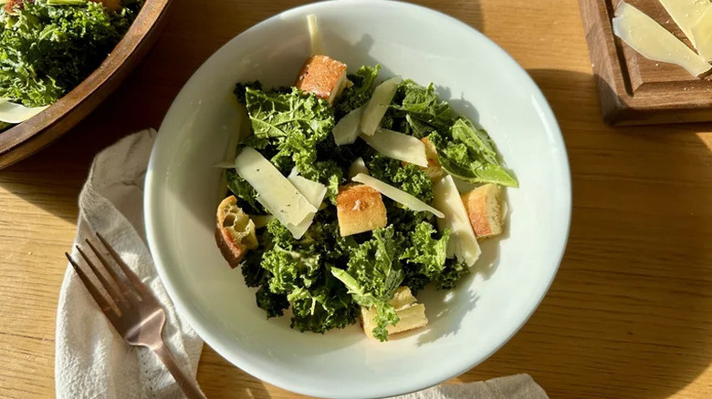 Kale caesar salad in a bowl with croutons and parmesan