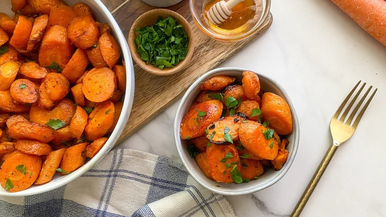 Bowl of honey glazed carrots with fresh herb garnish