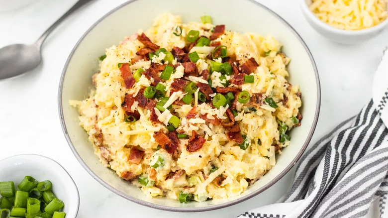 Bowl of loaded baked potato salad with bacon and green onion