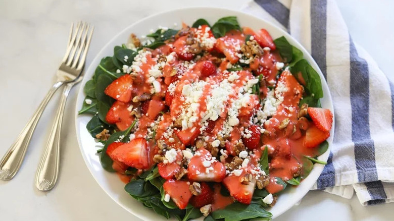 Spinach salad loaded with strawberries, walnuts, and goat cheese