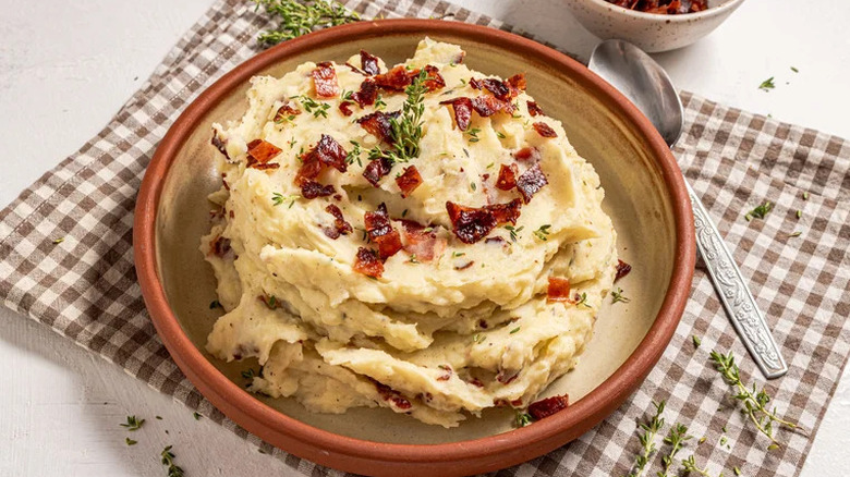 Pile of bacon mashed potatoes with bacon and thyme on top