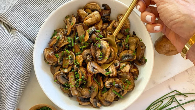 Bowl of sautéed mushrooms with fresh chives
