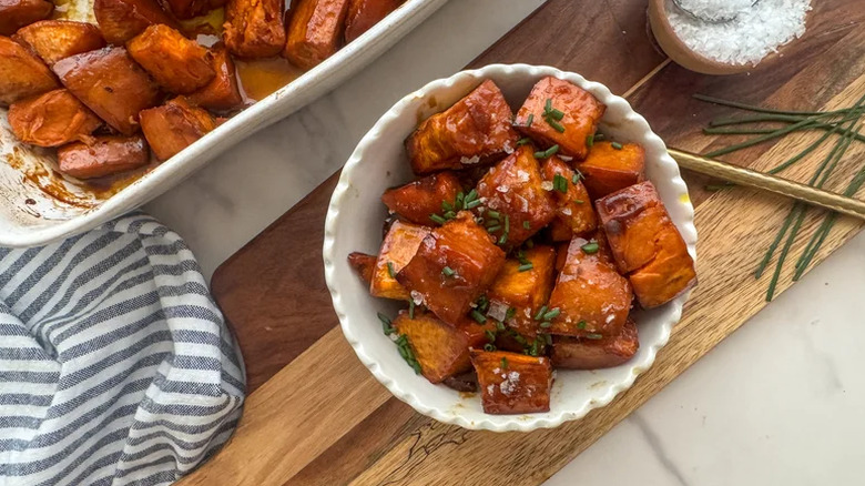 Bowl of candied yams with wooden board