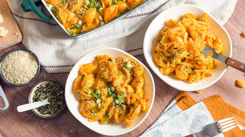 Kimchi mac and cheese in bowls on a wooden table.