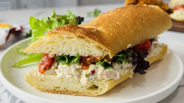 Sandwich on a plate with greens and veggies