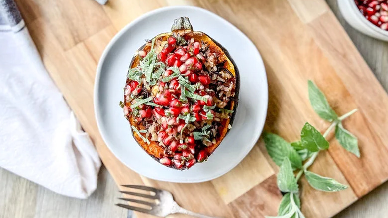 Pomegranate-topped squash on a cutting board