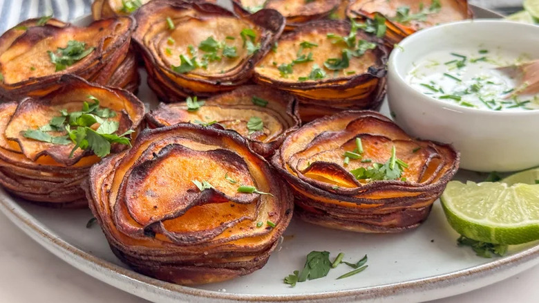 Crispy potato stacks on a plate with lime and sauce