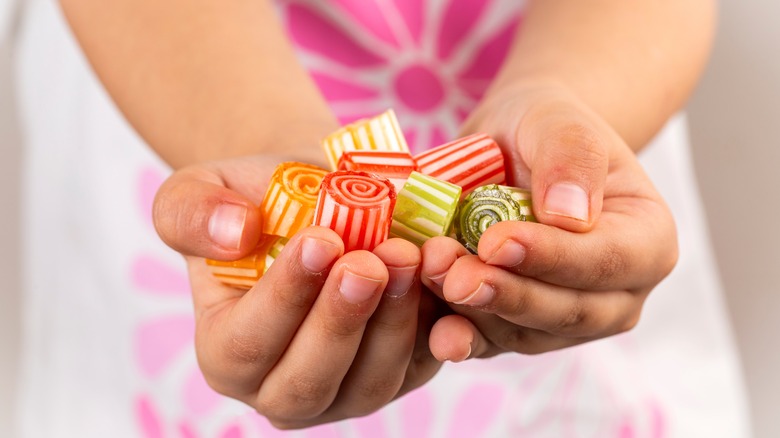 Little girl holding handful of hard candies