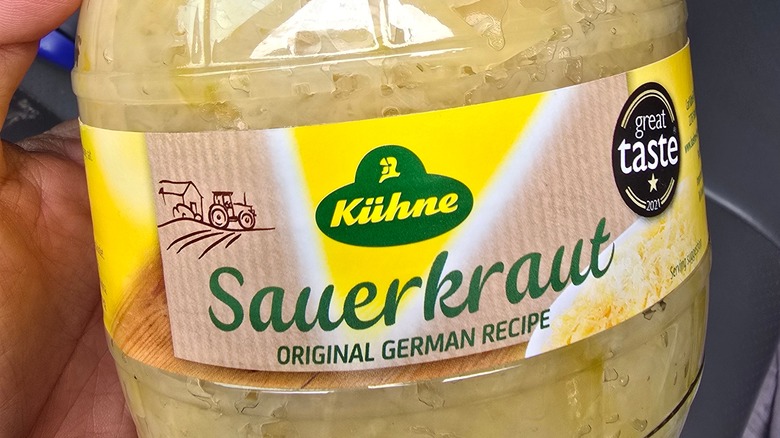 Hand holding jar of sauerkraut