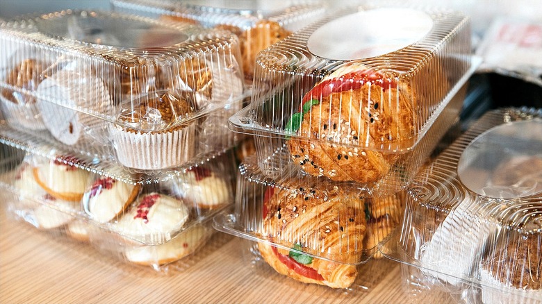 Croissants, muffins, and cookies with sprinkles in rectangular plastic containers