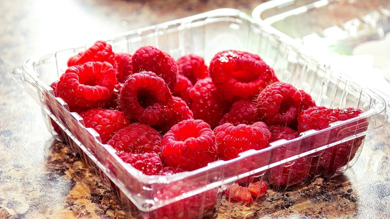 Fresh raspberries in an open plastic clamshell container