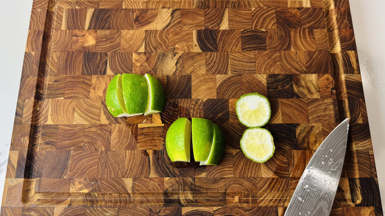 Lime sliced into wedges on wooden board