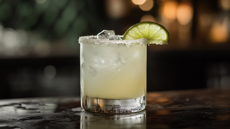 a margarita in a short, salt-rimmed glass with lime wedge