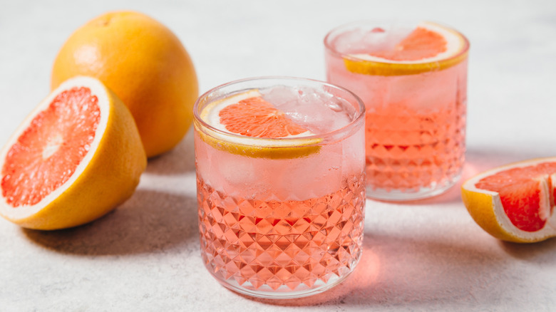 two paloma cocktail surrounded by sliced grapefruits