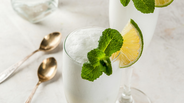 two glasses of sgroppino in glass flutes garnished with mint and lime