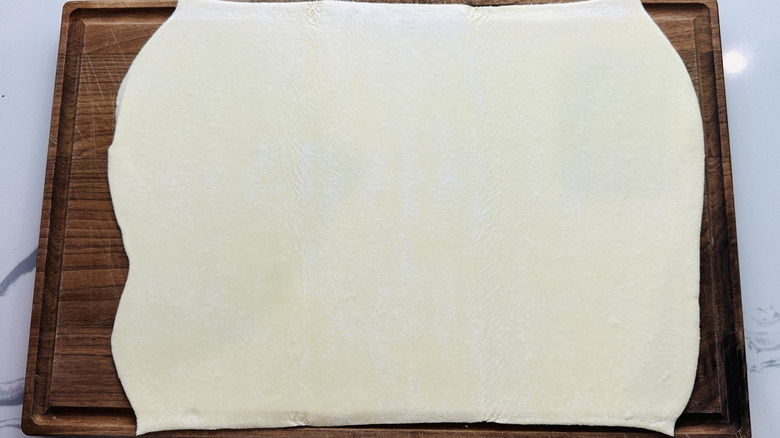 Rolled puff pastry on cutting board