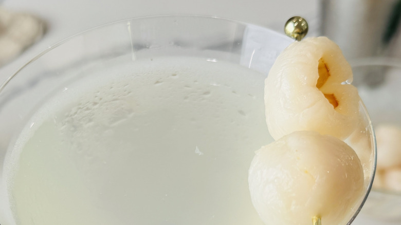 closeup of lychee martini in glass with lychee garnish
