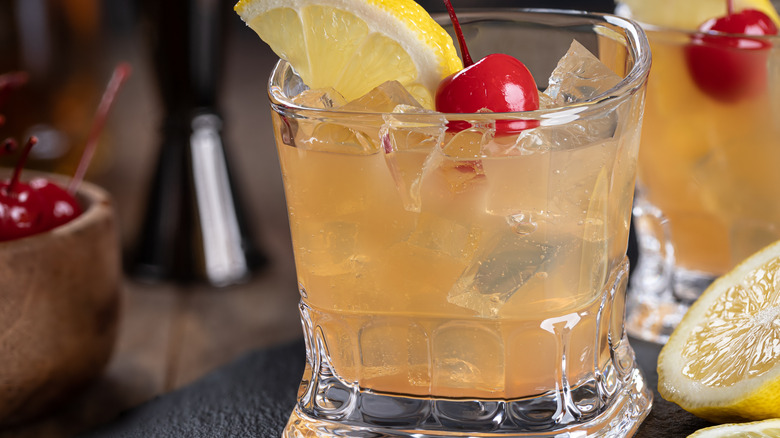 Mezcal sour cocktail with a cherry and lemon slice garnish