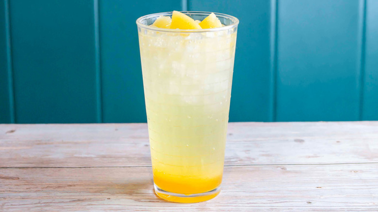 Pineapple soda cocktail with fresh cubes of pineapple on top