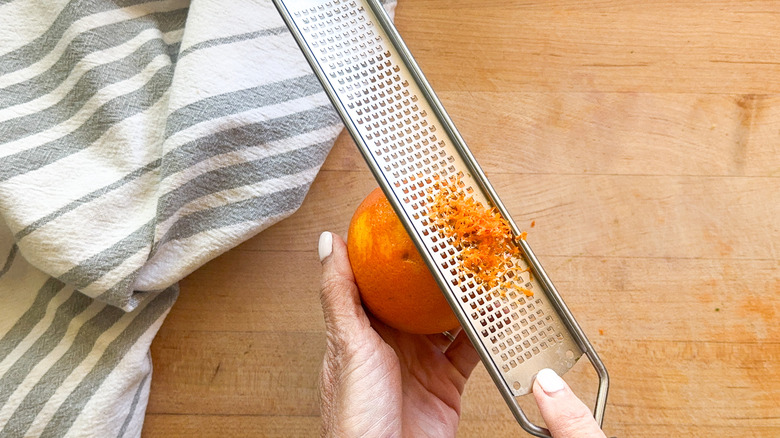 hands zesting orange