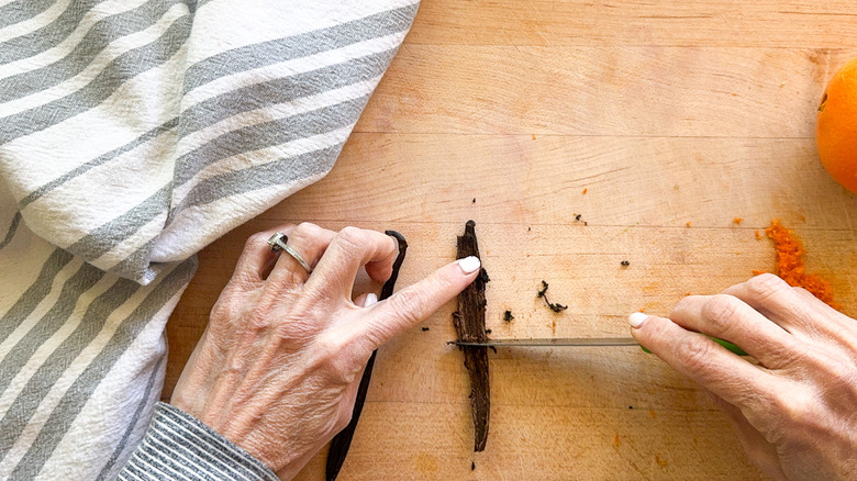 hands removing seeds from vanilla pod