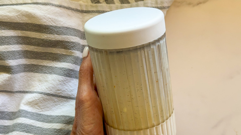 hand holding container of mixture