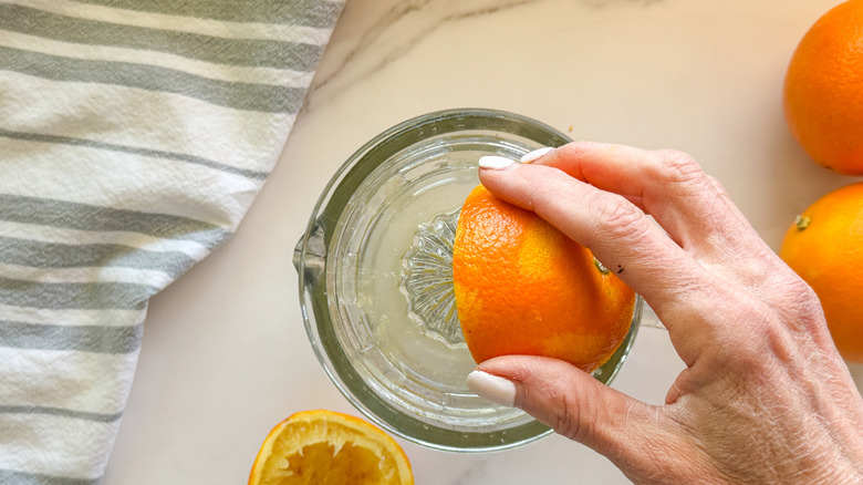 hand juicing an orange