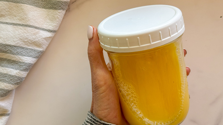 hand holding jar of juice