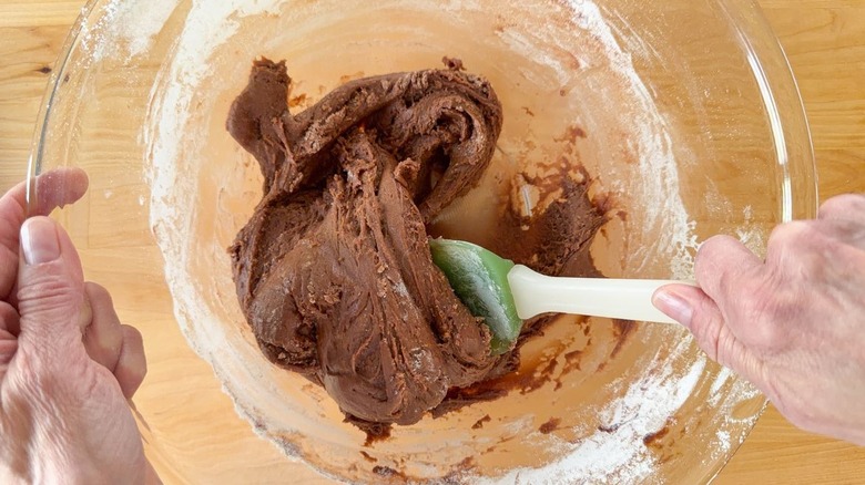 Stirring 3-ingredient Nutella donuts dough in glass bowl with rubber spatula