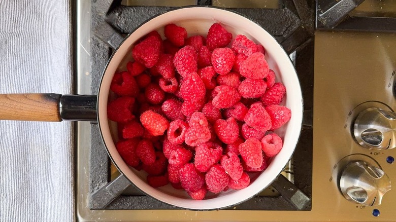 Fresh raspberries in saucepan on stovetop