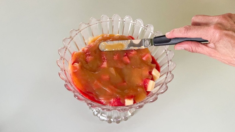 Spreading lemon curd over poundcake and raspberry puree in trifle dish