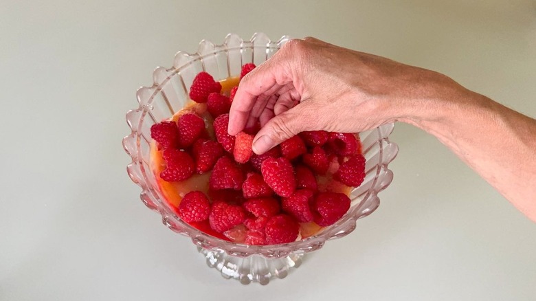 Layering fresh raspberries in trifle dish