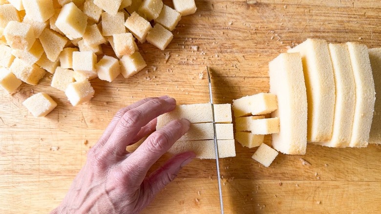 Cutting poundcake into cubes on cutting board