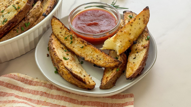 hand dipping wedge in ketchup