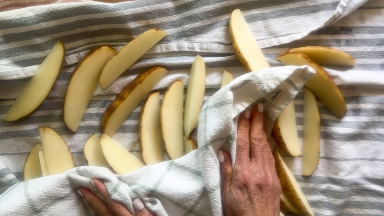 hands drying potatoes with dish towel