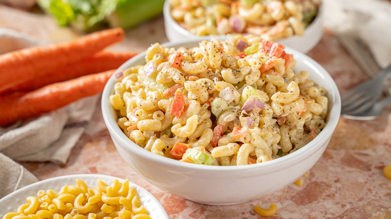 A creamy bowl of macaroni salad sits on a table