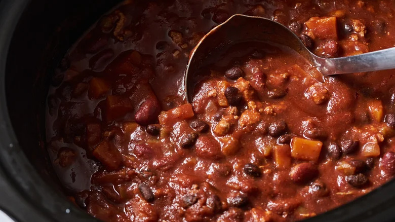 Chili with a ladle in a slow cooker