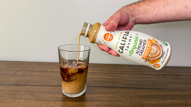 Hand pouring Califia Farms pumpkin spice creamer