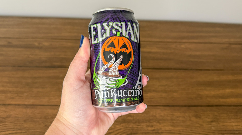 Hand holding can of Elysian punkuccino coffee pumpkin ale