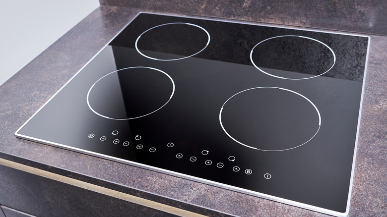 An induction cooktop with four burners and multiple function buttons