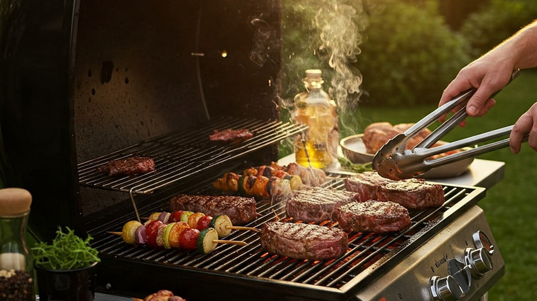 Person grilling meats and vegetables