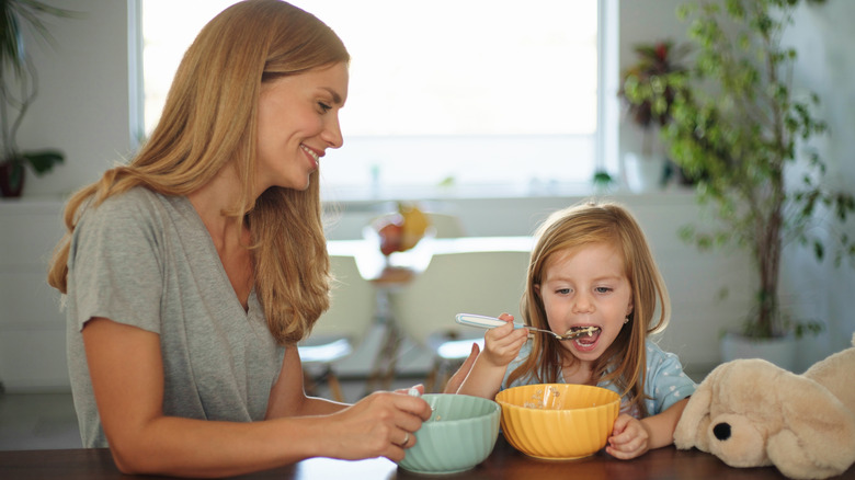 mom and kid eating cereal